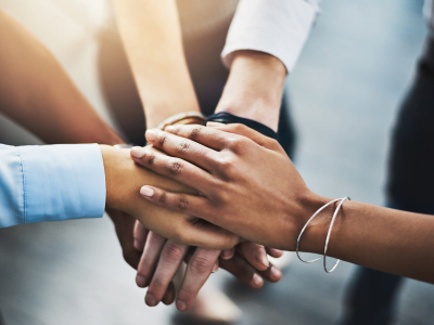 A picture of 5 hands stacked on top of each other (like making a pact)