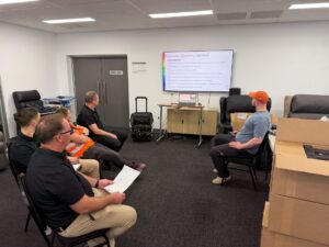 Hands-on demonstration of ceiling track hoist installation during technical training
